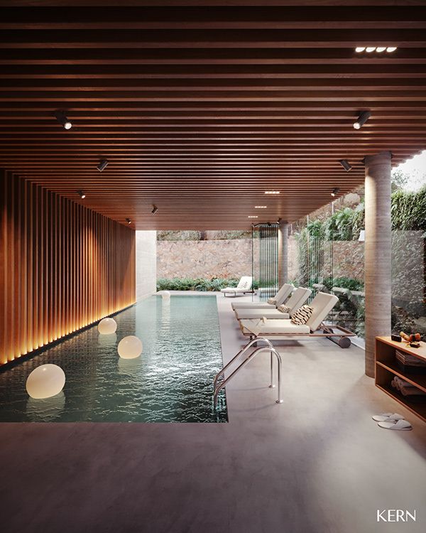 an indoor swimming pool with lounge chairs next to it