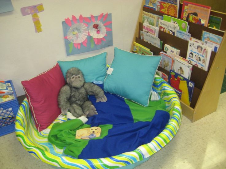 a stuffed animal sitting on top of a bed in a child's playroom