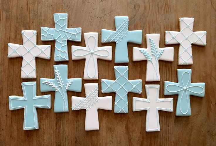 many decorated cookies are arranged on a table together, including one with a cross in the center