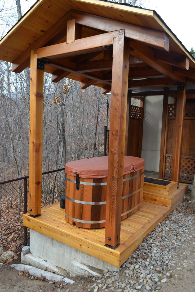 a wooden gazebo with a hot tub in it