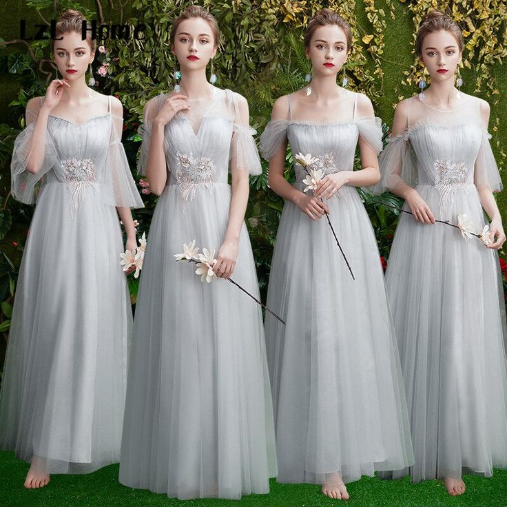 four bridesmaids in long gray dresses with flowers on their bouquets and one holding a flower