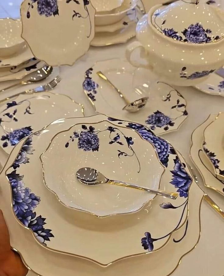 a table topped with lots of white and blue plates