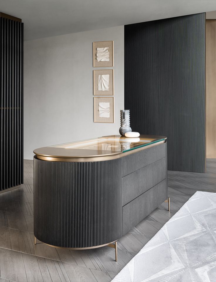 a modern kitchen with an oval counter top and gold trim on the front, along with black cabinets