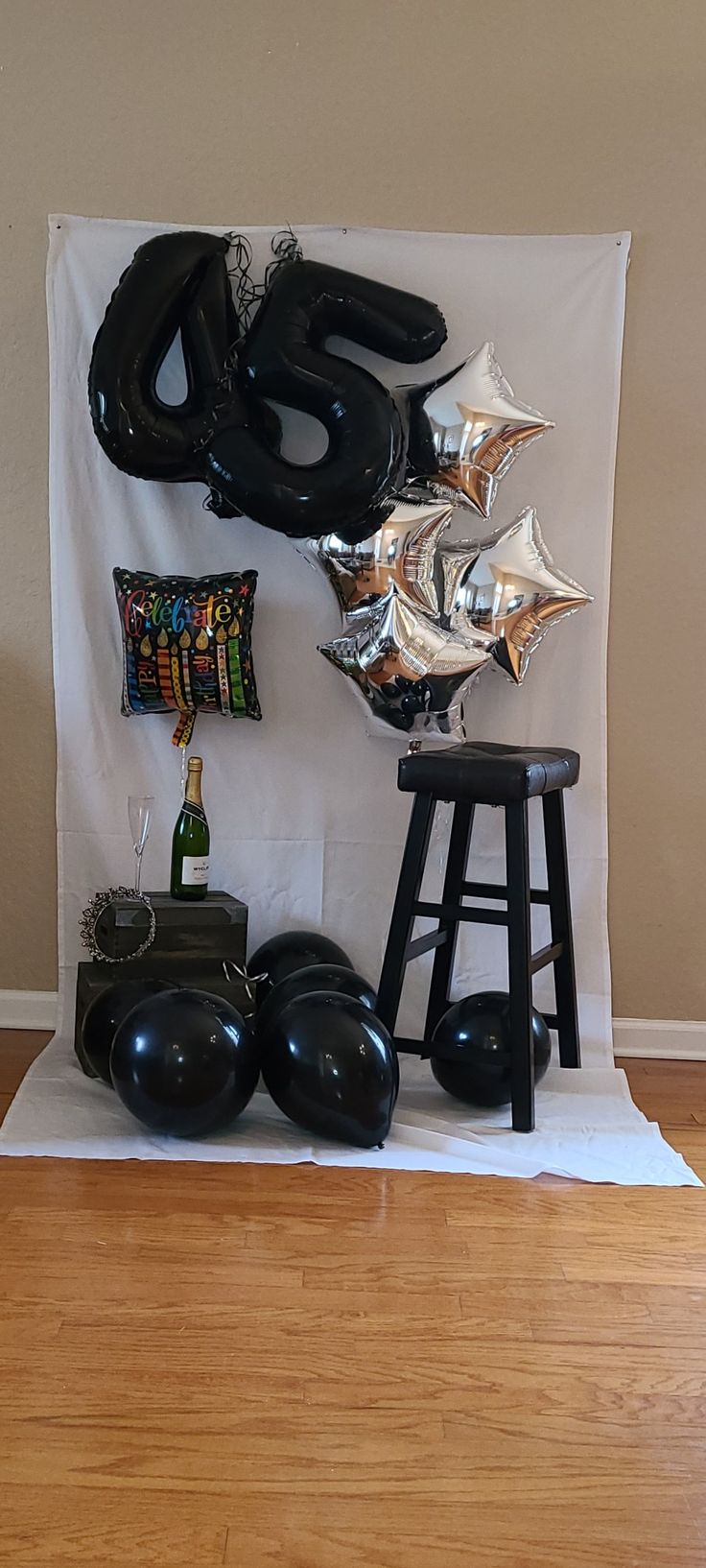 balloons and other items are arranged on a white backdrop in front of a wooden floor