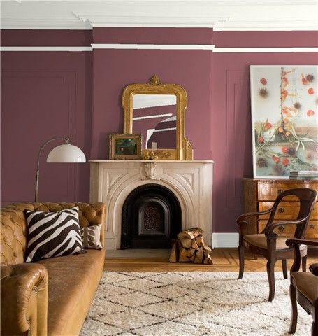 a living room filled with furniture and a fire place in front of a painting on the wall