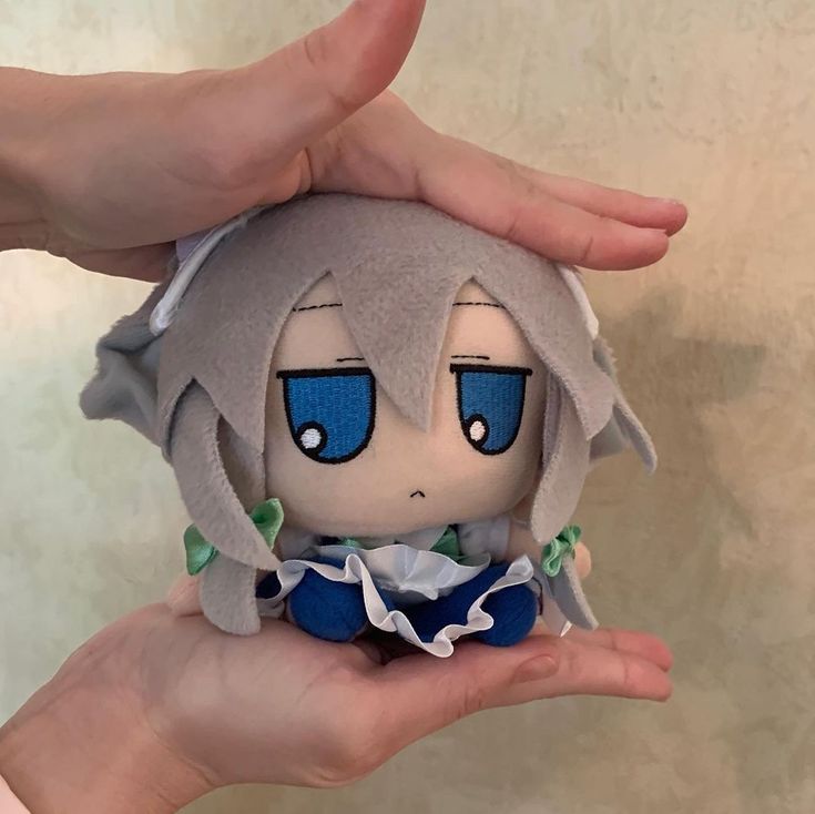 a person holding a stuffed animal in their hand with both hands on the other side