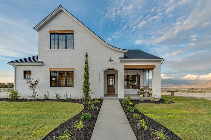 a white house sitting on top of a lush green field