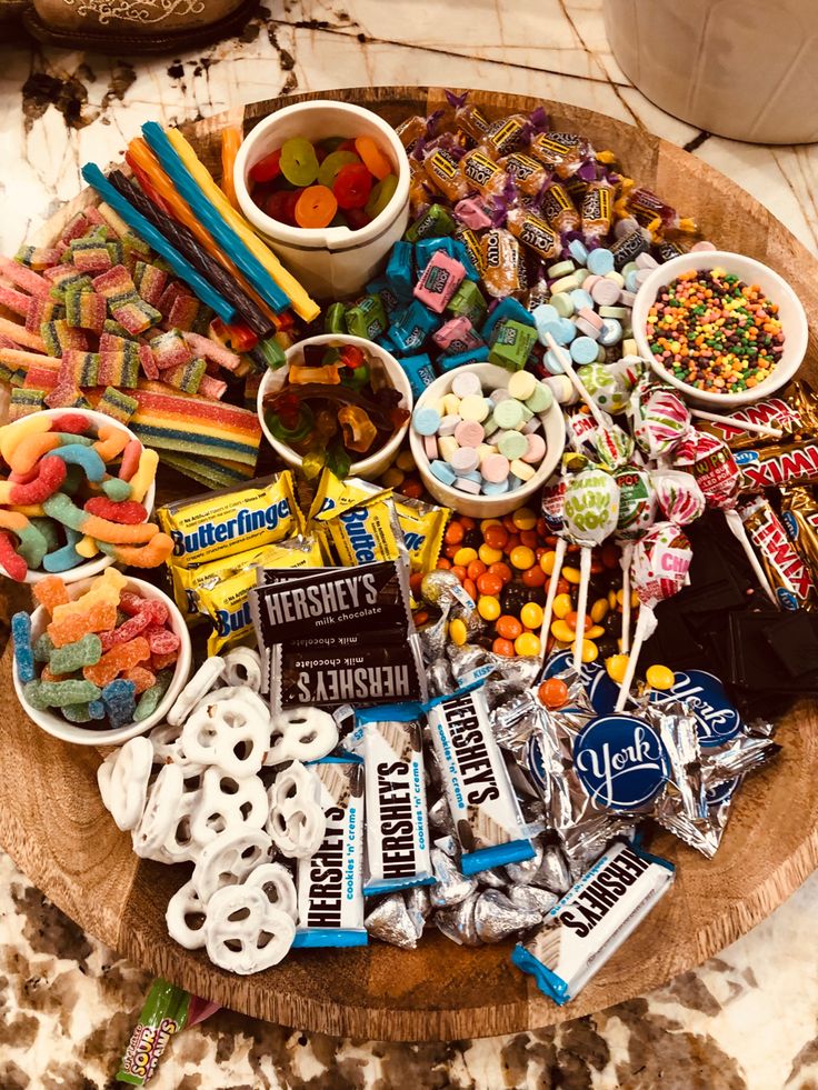 a wooden platter filled with candy and candies