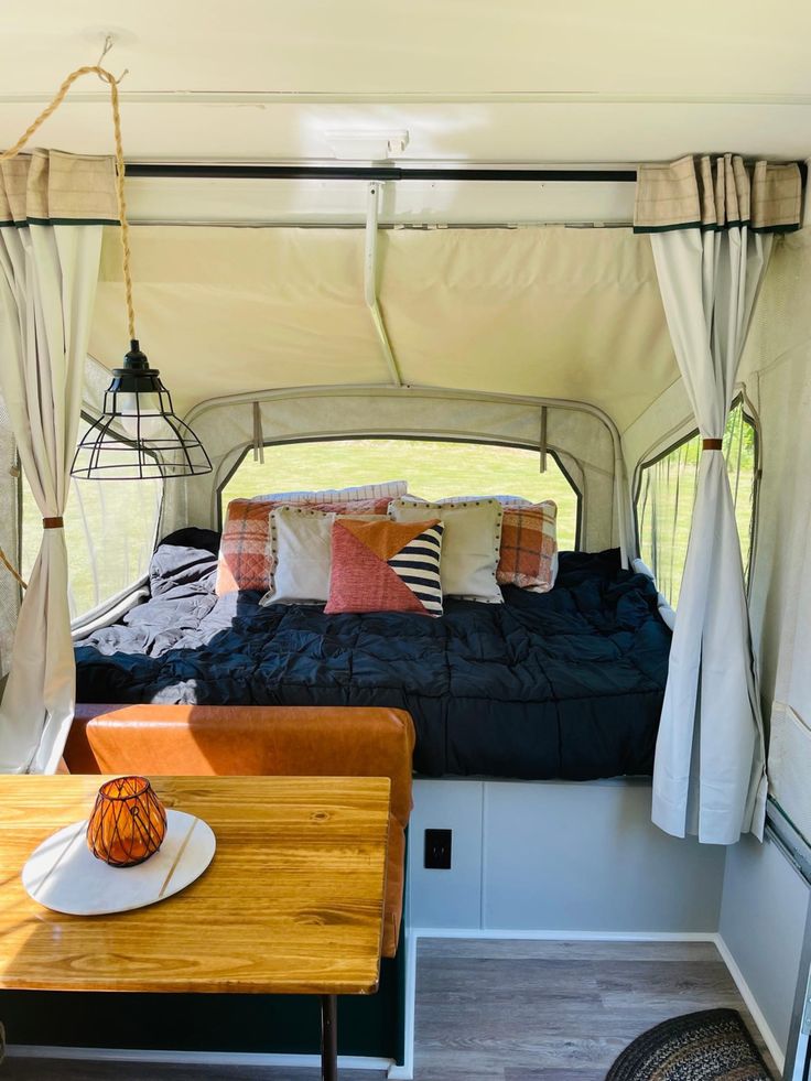 the inside of a camper with a bed and table