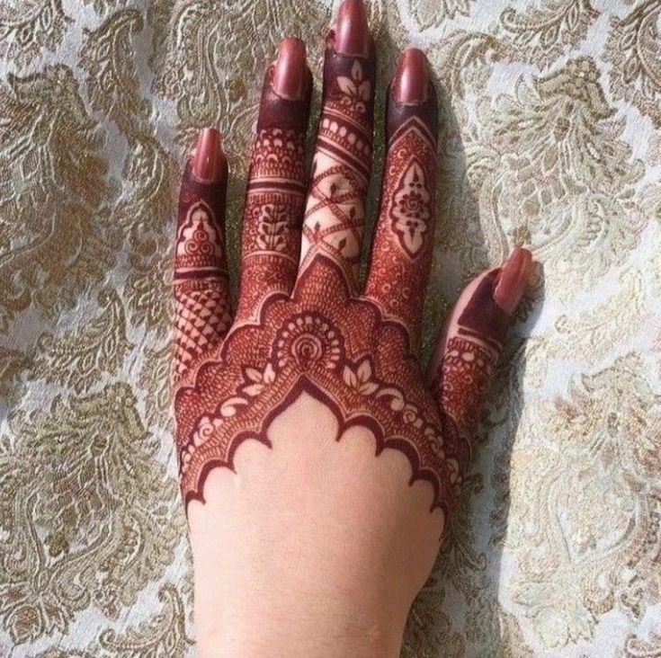 a woman's hand with henna tattoos on it