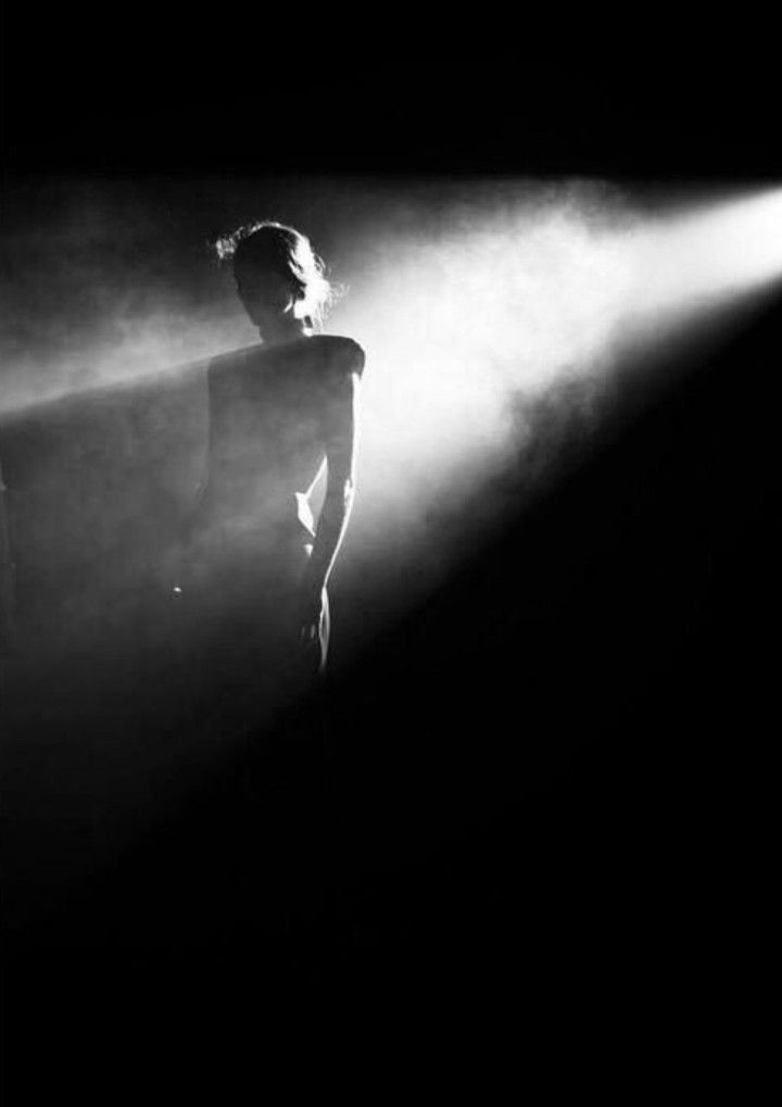 a man standing in front of a spotlight on a stage