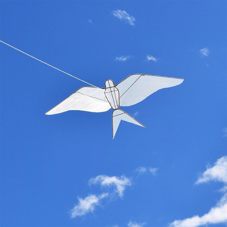 a white kite flying in the blue sky on a string with two strings attached to it