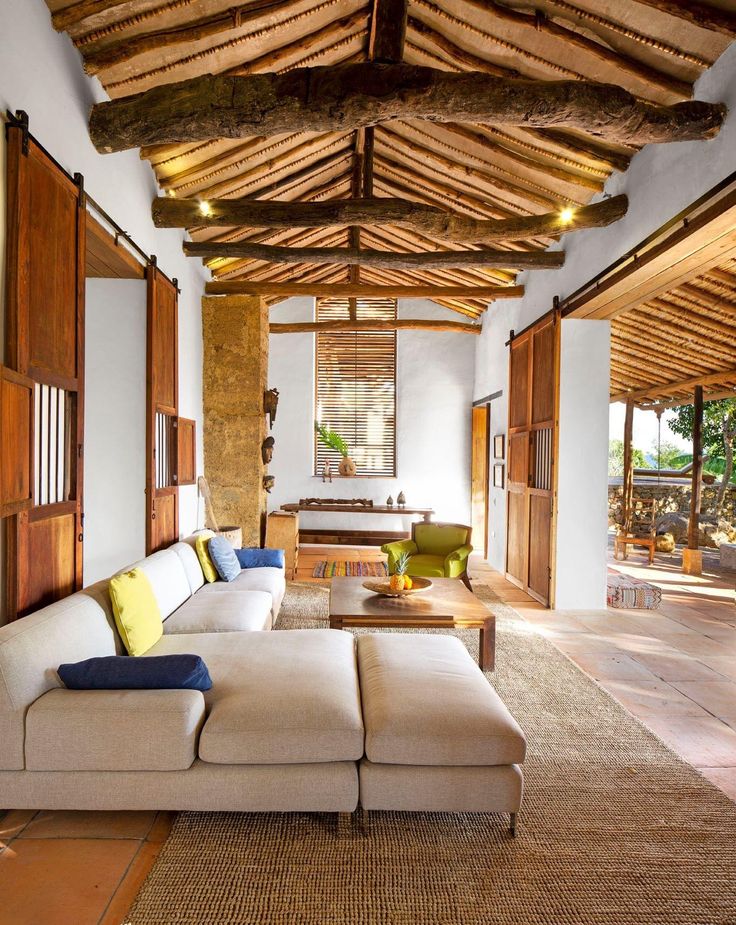 a living room with couches, tables and windows in the ceiling is made of wood