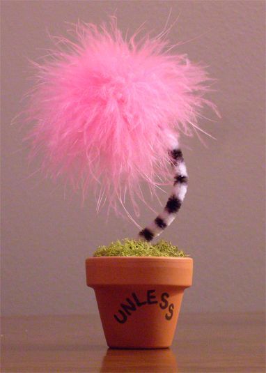 a pink fuzzy ball on top of a potted plant with the word june's written below it