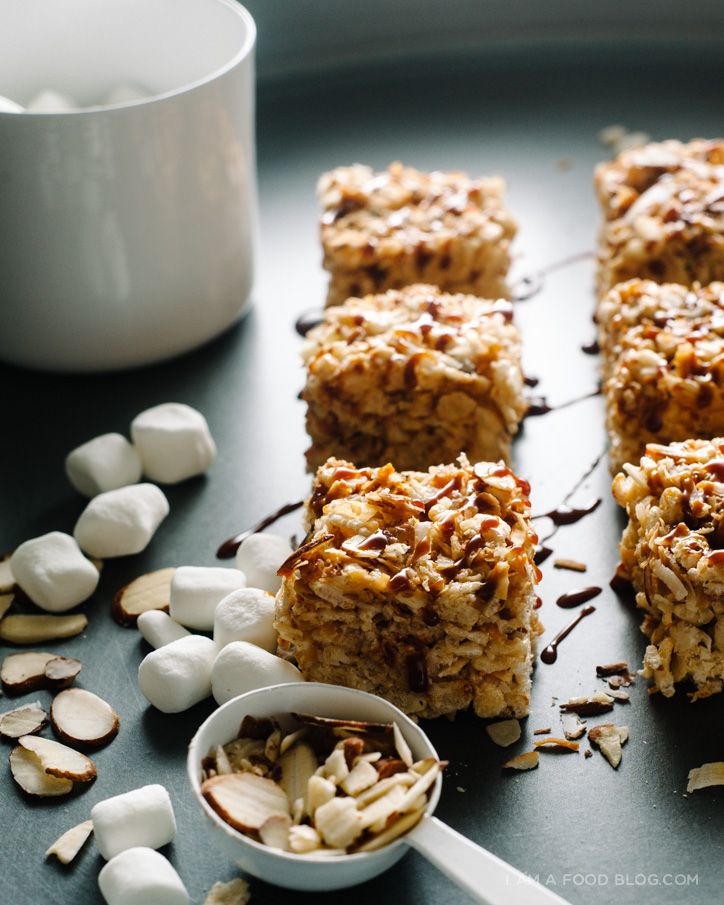 there are many pieces of granola on the table with marshmallows next to it