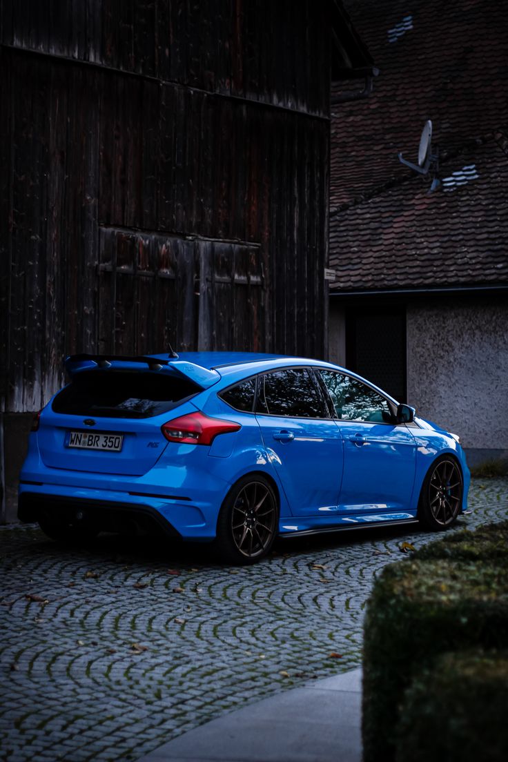 a blue car parked in front of a building