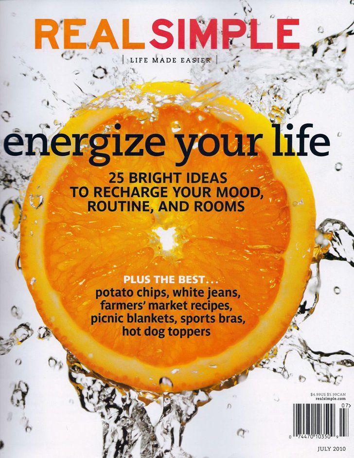 the cover of real simple magazine shows an orange being sliced in half with water splashing around it