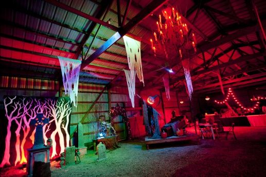 the inside of a building lit up with red and blue lights, trees and streamers