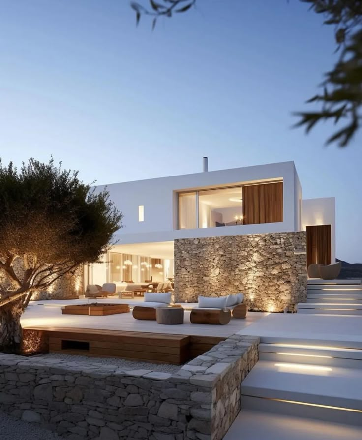 a modern house with stone walls and steps leading up to it