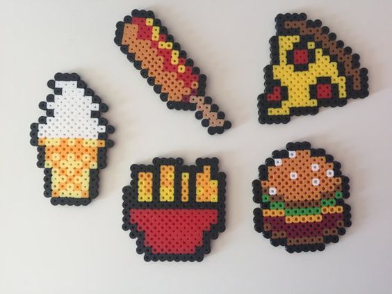 four pixel art magnets depicting different foods and beverages on white surface, with one being an ice cream cone