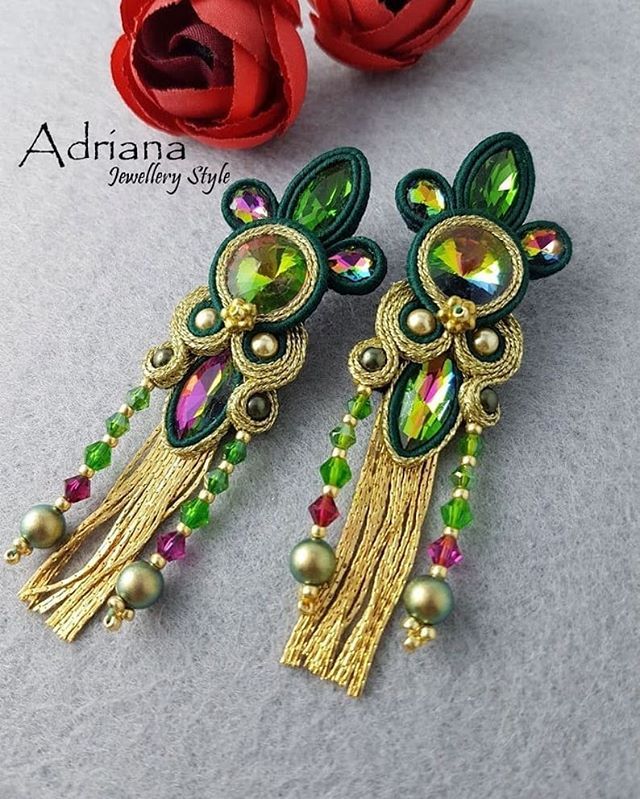 two pairs of earrings with beads and flowers on the table next to eachother