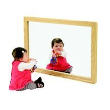 two small children sitting in front of a mirror