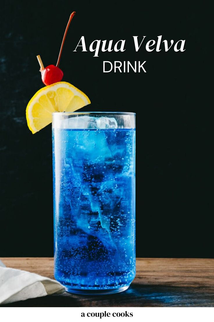 a blue drink in a tall glass with a cherry and lemon garnish on top