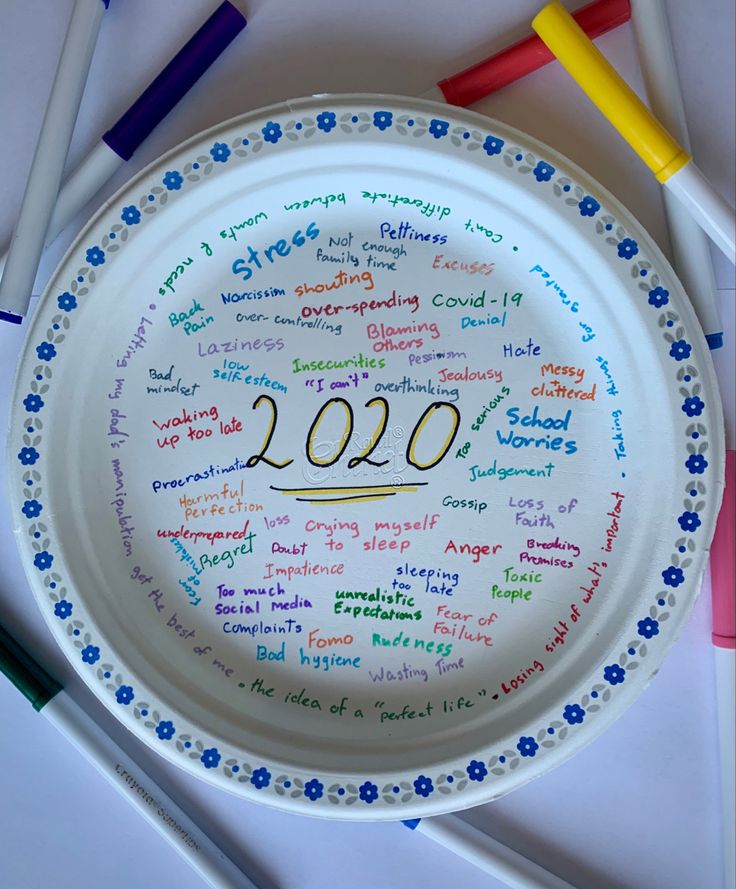 a paper plate with writing on it next to crayon markers and pencils