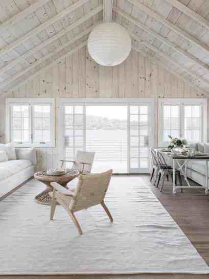 a living room filled with furniture and a white rug on top of a hard wood floor