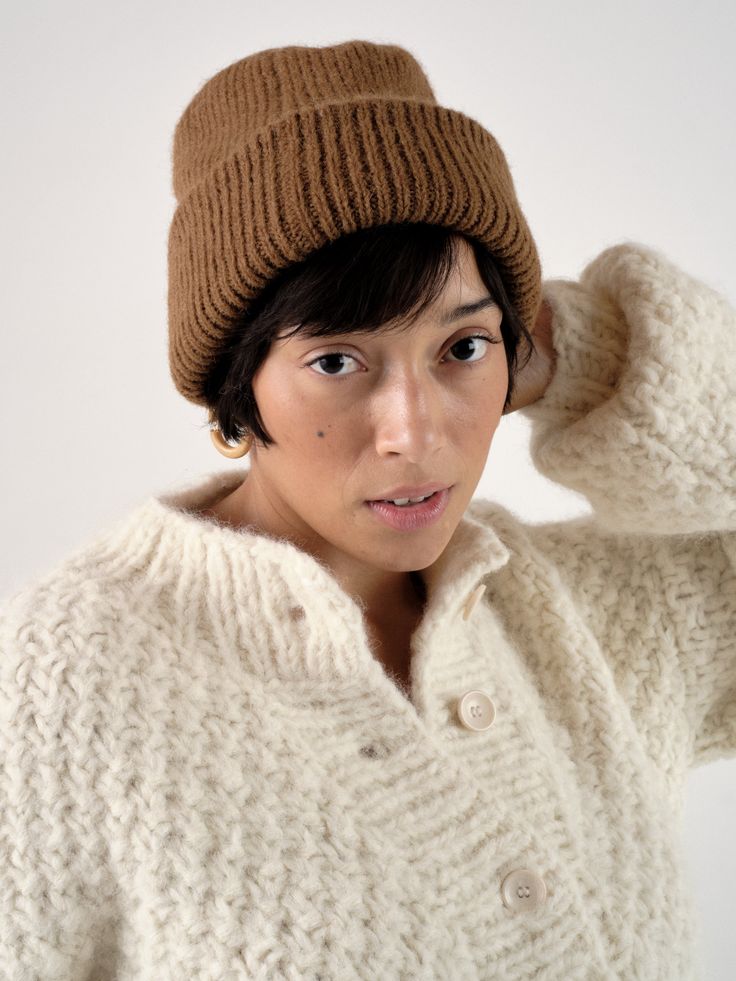 The OZMA Sweater Collection is made in Peru with the finest alpaca and wool yarns. All factories and yarn manufacturers are proudly Promperu Fair Trade Certified. A seasonal antidote to our beloved Bandana, our favorite beanie in this season's Caraveli yarn will keep you warm through any weather. Inspired by the cool alpine climate of the Sierra, the knitted accessory is luxury for the everyday. Classic Alpaca Sweater For Winter, Cozy Alpaca Hats For Fall, Knitted Alpaca Hat For Fall, Casual Brown Alpaca Outerwear, Cozy Wool Hats For Fall, Brown Alpaca Winter Outerwear, Chunky Knit Wool Hat For Fall, Cozy Merino Wool Hats For Fall, Soft Knit Merino Wool Hat For Fall