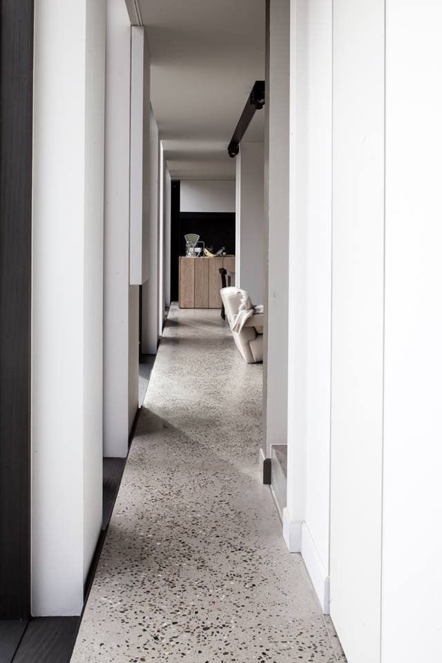 an empty hallway with white walls and flooring is seen in this image from the front door