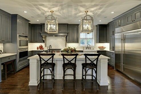 an image of a kitchen with gray cabinets and white counter tops, including the island