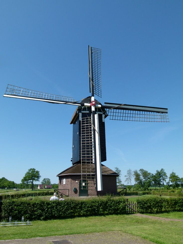 a windmill in the middle of a grassy field