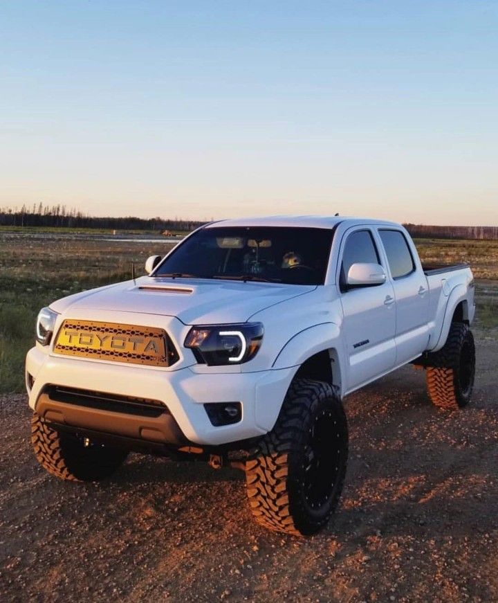 a white truck parked on top of a dirt road