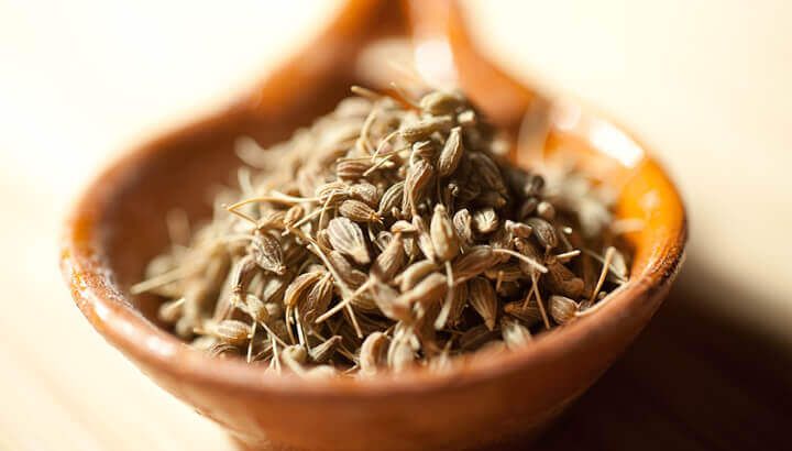 a wooden bowl filled with seeds on top of a table