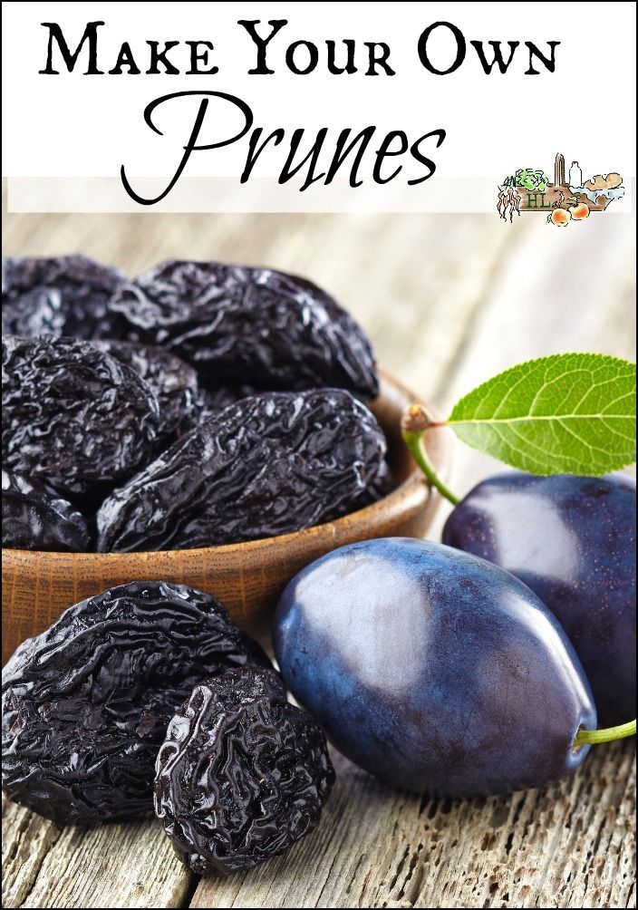 plums and leaves on a wooden table with the words make your own prunes