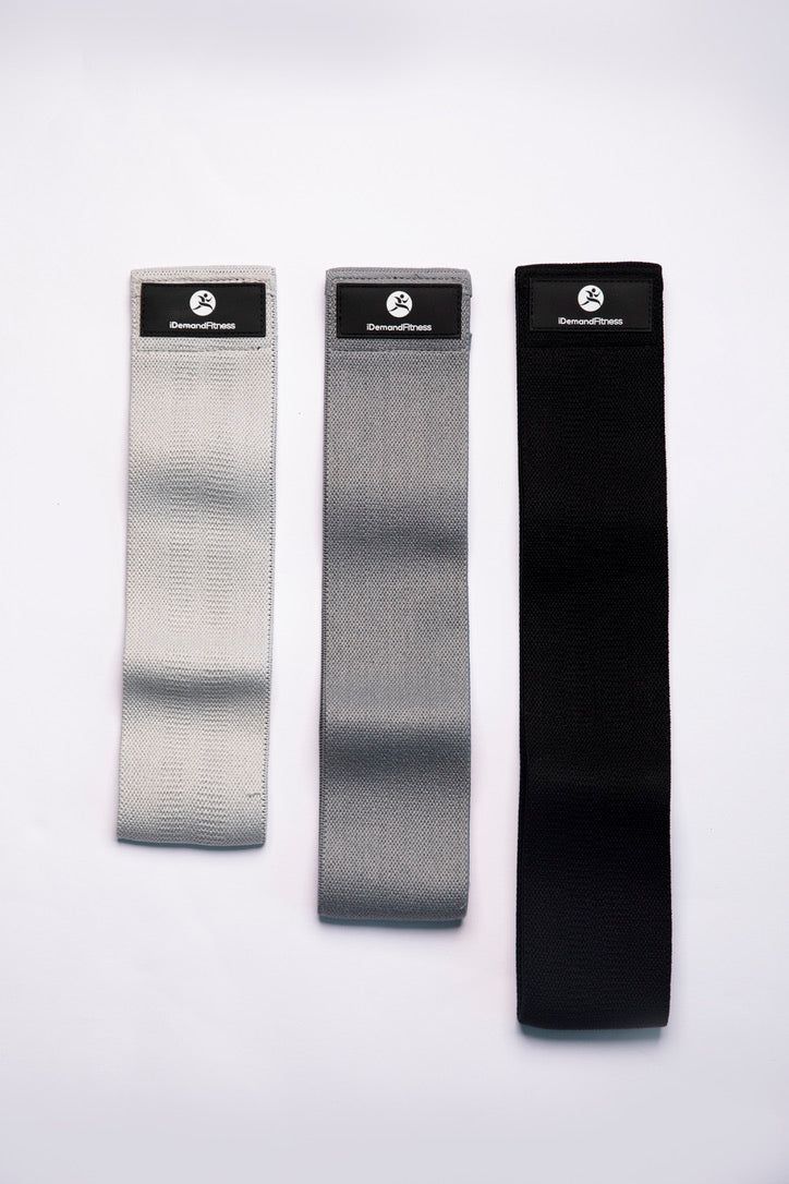 three pairs of black, grey and white socks on a white surface with the same color