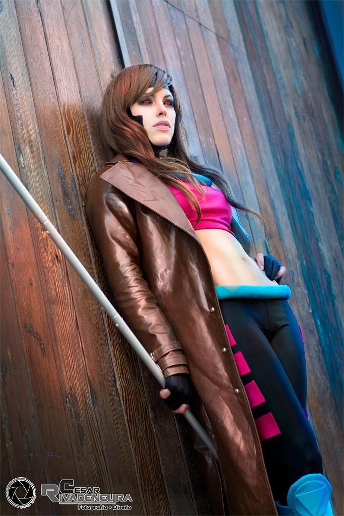 a woman is leaning against a wooden wall wearing a brown coat and leggings