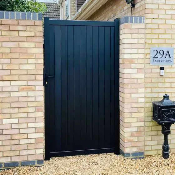 a brick wall with a black door and mailbox on it's side next to a sign that says 29a