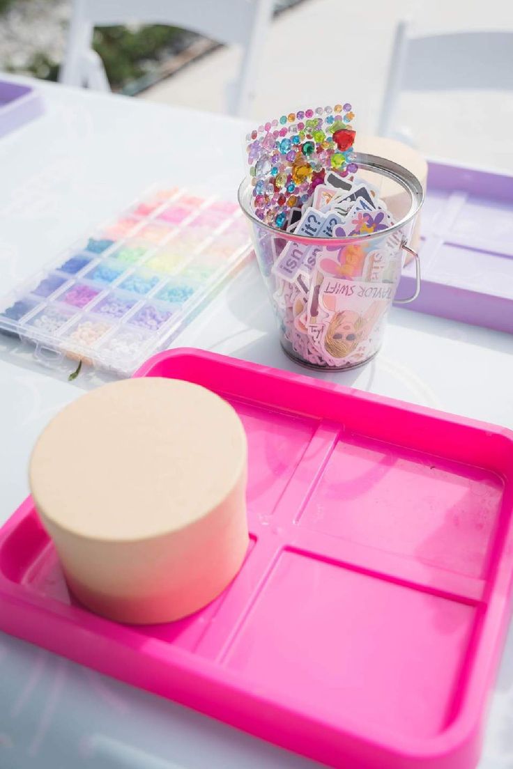 there is a plastic tray with buttons in it on the table next to a cup