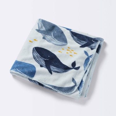 a blue and white blanket with whales on it