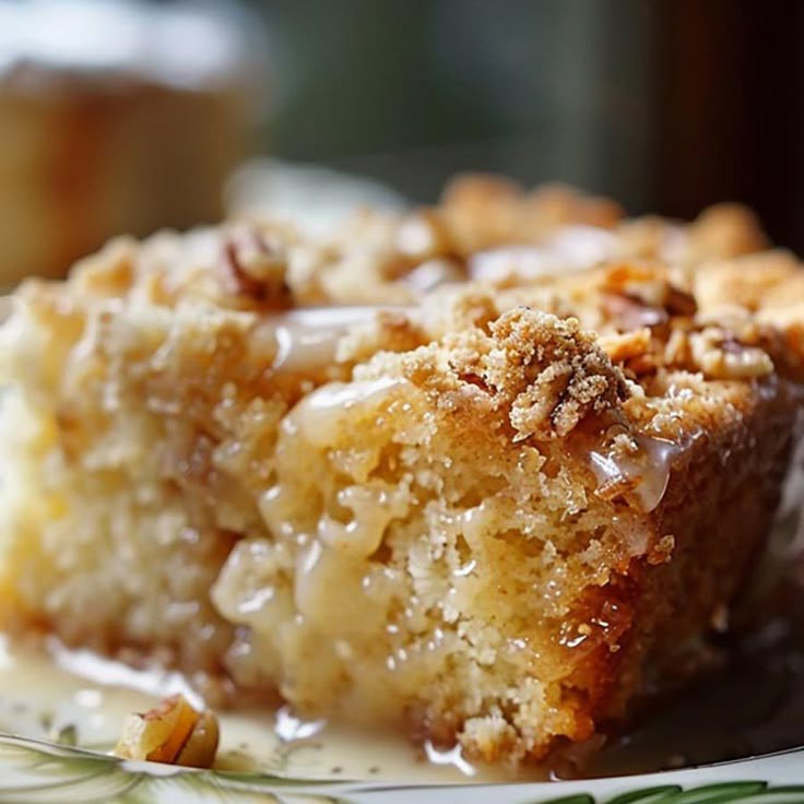 a close up of a piece of cake on a plate with icing and nuts