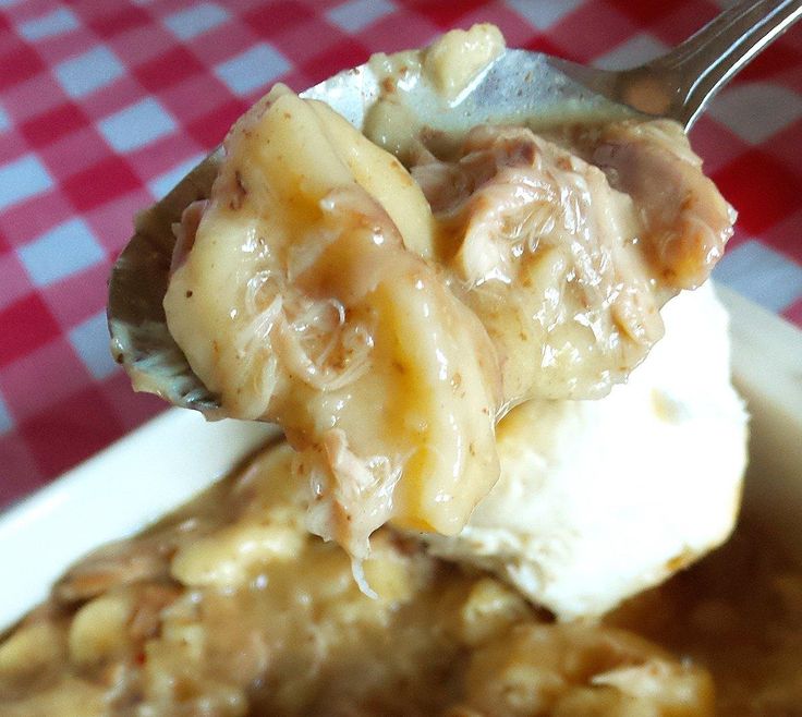 a spoonful of ice cream and some kind of food on a plate with a checkered table cloth