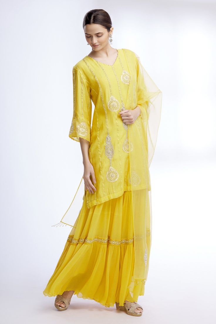 Yellow kurta with floral embroidered motifs and stripes detail. Paired with sharara and sheer dupatta.
Components: 3
Fabric: Pure Silk Chanderi, Chiffon, Organza
Neckline: V neck
Sleeve Length: Three quarter
Color: Yellow
Embroidered
Floral motif work
Sheer dupatta
Tiered sharara
Bead and pearl work
Flared sleeves - Aza Fashions Kurta And Sharara, Sheer Dupatta, Yellow Kurta, Pearl Work, Blue Kurta, Kurta Set For Women, Embroidered Motifs, Sharara Set, Fashion App