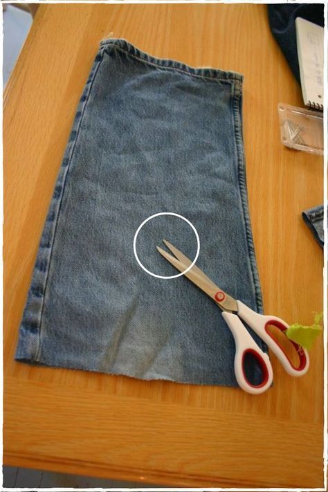 two pairs of scissors sitting on top of a pair of jeans