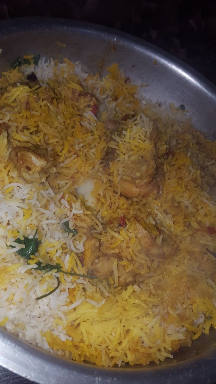 a pan filled with rice and chicken on top of a stove