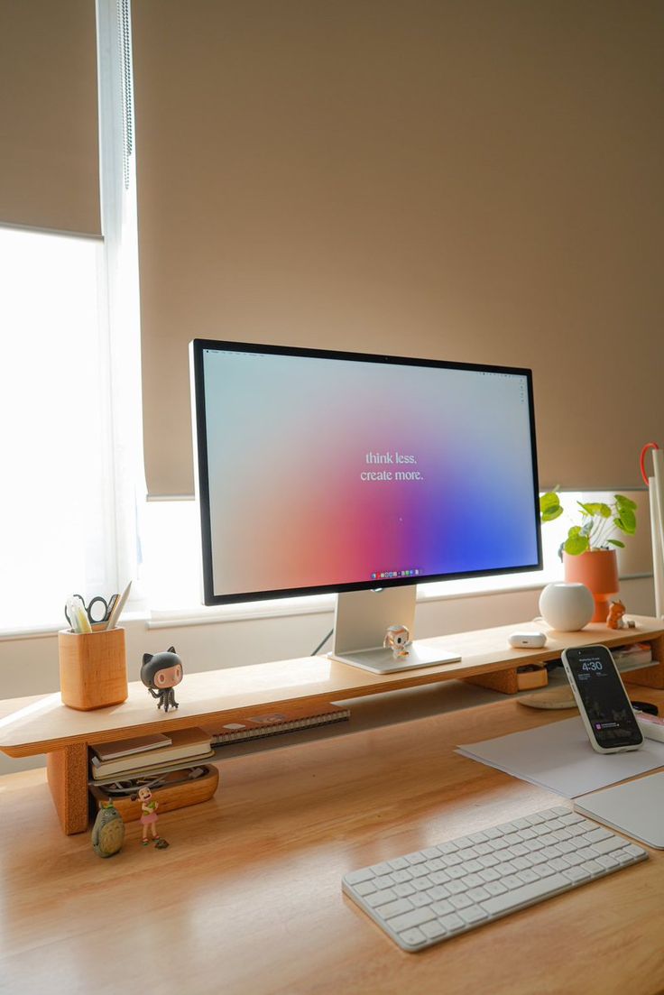 a computer monitor sitting on top of a wooden desk next to a keyboard and mouse