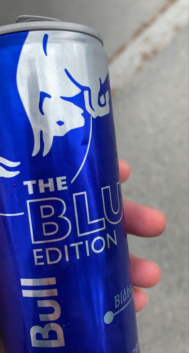 a person is holding a blue beer in their hand