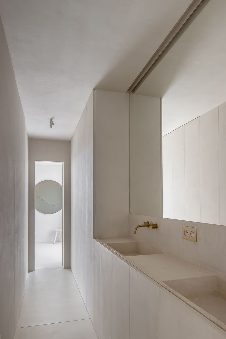 an empty bathroom with white walls and flooring is seen in this image from the hallway