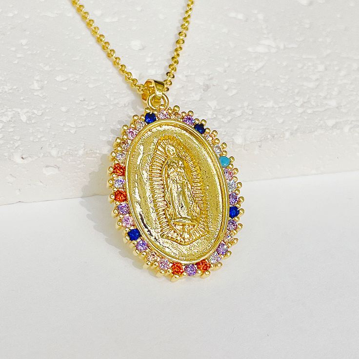 Experience the power of faith and divine protection under the devotional protection of the Blessed Virgin Mary. The Virgin Mary will always watch over and protect you, and you will be inspired and empowered. The Religious Virgin Mary Gold Virgencita Necklace is displayed with beautiful attention to detail. The pendant has a beautifully designed texture that makes the image come out and has everything you would want in a Virgin Mary Virgencita Necklace. Make a statement and show your devotion wit Spiritual Healing Jewelry With Miraculous Medal, Multicolor Our Lady Of Guadalupe Jewelry As A Gift, Multicolor Our Lady Of Guadalupe Jewelry Gift, Spiritual Our Lady Of Guadalupe Pendant Necklace, Spiritual Medallion Jewelry, Spiritual Miraculous Medal Pendant Jewelry, Spiritual Jewelry With Miraculous Medal For Blessing, Spiritual Our Lady Of Guadalupe Jewelry Gift, Spiritual Locket Necklace For Blessing